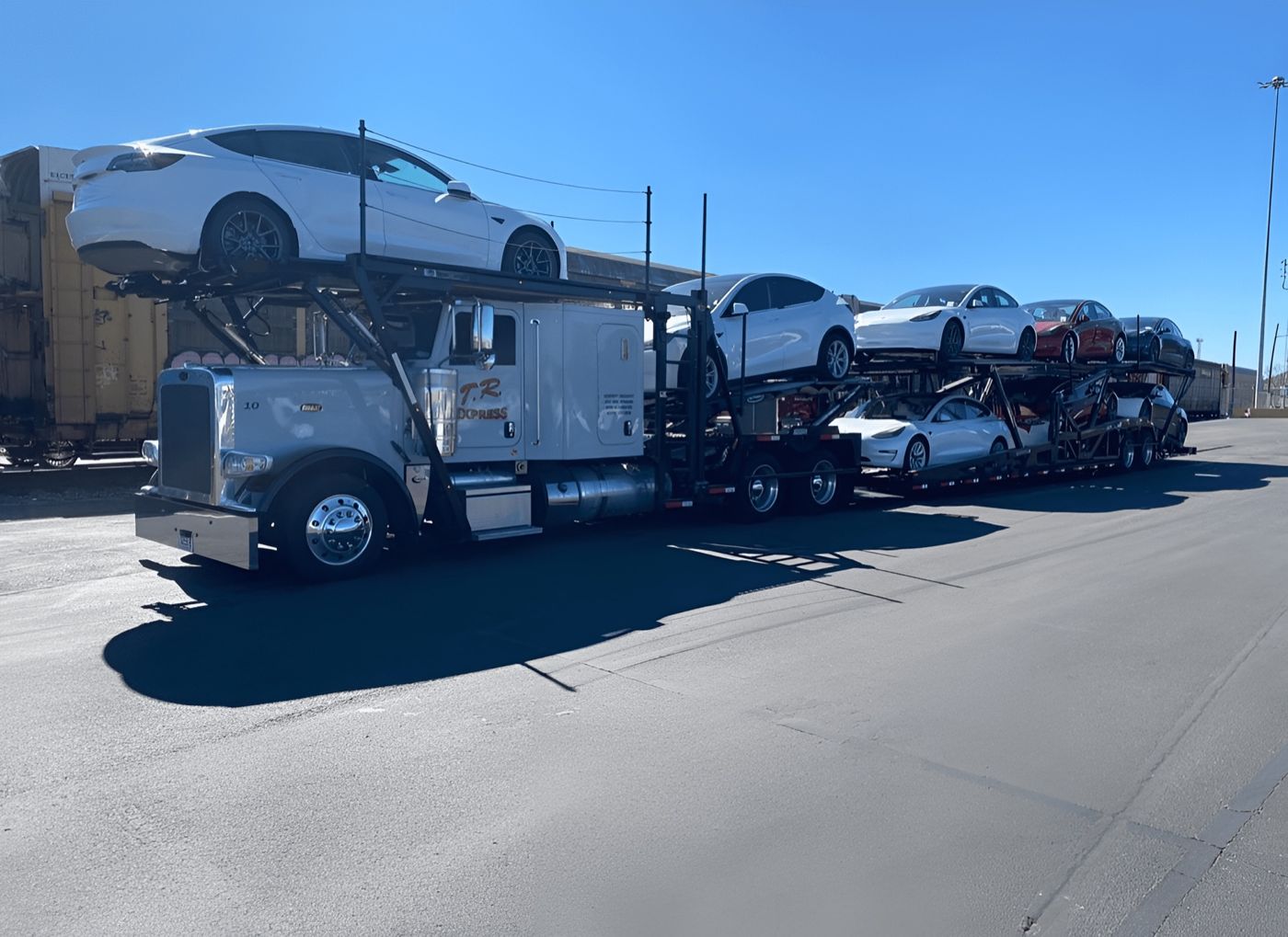 Car carrier loaded with electric vehicles at a rail yard