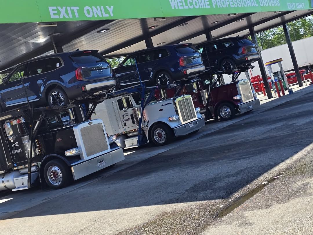 Car hauler loaded under a dealership canopy