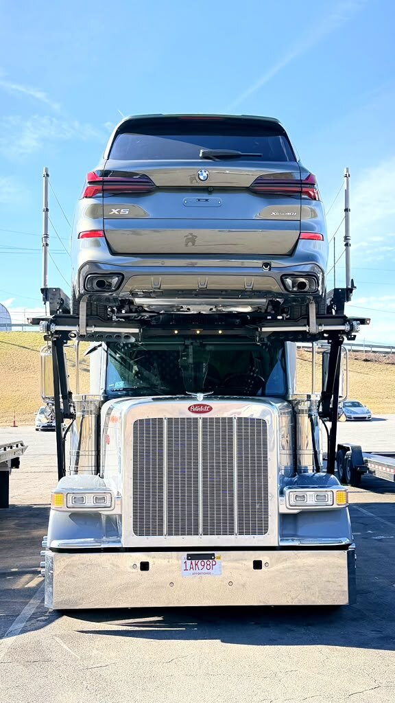 Chrome Peterbilt car hauler with a BMW X5 on top