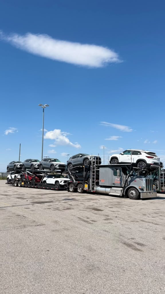 Fully loaded car carrier on a sunny lot